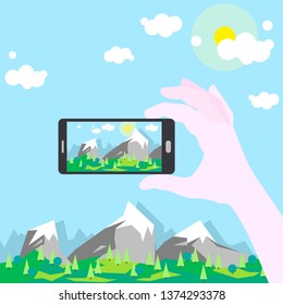Smartphone in hand against the background of the landscape. Mountain landscape. Traveling with a smartphone. Photos on the smartphone.