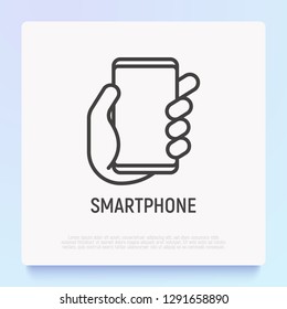 Smartphone in hand thin line icon. Modern vector illustration.