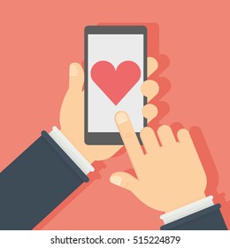 Smartphone with like button. Hands holding smartphone with heart-shaped like button on the screen. Concept of social networks, sharing.