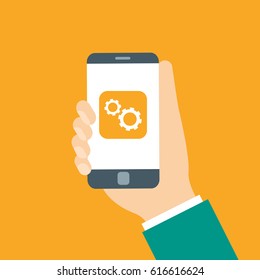 Smartphone with settings icon on screen. White gear wheels