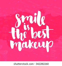 Smile is the best makeup. Inspirational quote handwritten with white ink and brush, custom lettering for posters, t-shirts and cards. Vector calligraphy on bright pink grunge background.