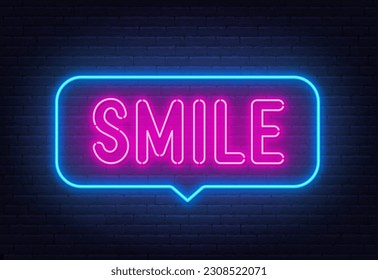 Smile neon sign in the speech bubble on brick wall background.