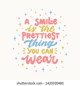 A smile is the prettiest thing you can wear. Iinspirational hand drawn lettering quote. In bright blue, pink, yellow colors. Motivational phrase. T-shirt print, poster, postcard, banner design. Female