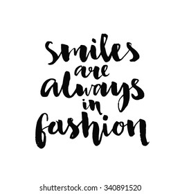 Smiles are always in fashion. Inspirational quote handwritten with black ink and brush, custom lettering for posters, t-shirts and cards. Vector calligraphy isolated on white background