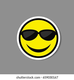 Smiley emoticon in sunglasses vector paper sticker.