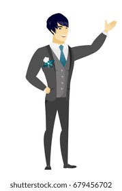 Smiling asian groom showing a direction. Full length of groom in a wedding suit pointing at something and showing a direction by hand. Vector flat design illustration isolated on white background.