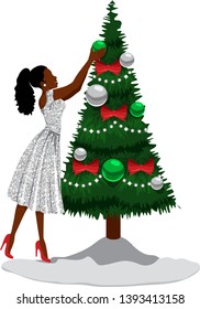 A smiling black woman in a silver party dress decorates a Christmas tree with an ornament