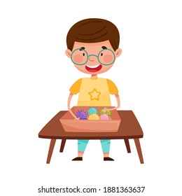 Smiling Boy at Desk Playing with Rubber Balls Vector Illustration