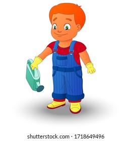 Smiling boy dressed in a shirt, denim overall, watertight boots and gloves holds a watering can in the right hand. Concept of a child helping out with the work around the house or in the garden.