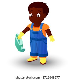 Smiling boy dressed in a shirt, denim overall, watertight boots and gloves holds a watering can in the right hand. Concept of a child helping out with the work around the house or in the garden.