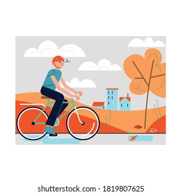 Smiling boy riding bicycle during leaf fall in autumn