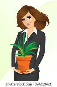 smiling business woman holding chlorophytum in a pot isolated on white background 