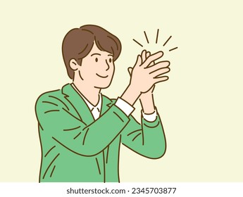 A smiling businessman clapping his hands.