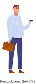 Smiling businessman or office worker in smart casual outfit is holding briefcase and using a smartphone, sending messages or browsing internet
