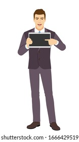 Smiling Businessman pointing at tablet computer. Full length portrait of Businessman in a flat style. Vector illustration.
