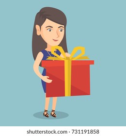 Smiling caucasian woman holding a box with a gift in hands. Full length of young happy woman holding a gift box. Woman buying a present. Vector cartoon illustration. Square layout.