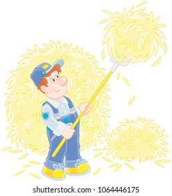 Smiling farmer tedding hay with a pitchfork in a hayloft