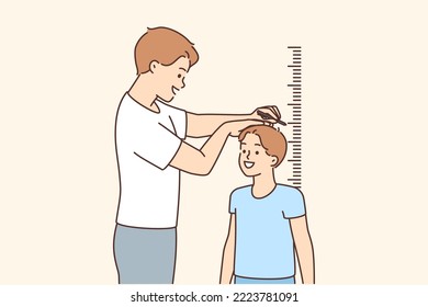 Kid with measuring tape. Smiling kid looking at numbers on tape measure.  Concept of measuring height or growing tall Stock Photo