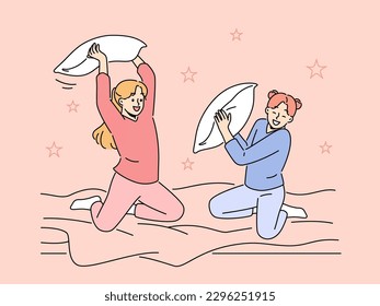 Smiling girls have fun engaged in pillow fight in bedroom. Happy children enjoy pajama party in bed at home. Vector illustration. 