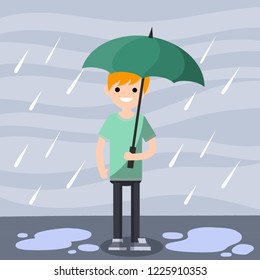 Smiling guy in green clothes standing with an umbrella in his hand in the rain. Drops of water fall down. Bad autumn weather.
