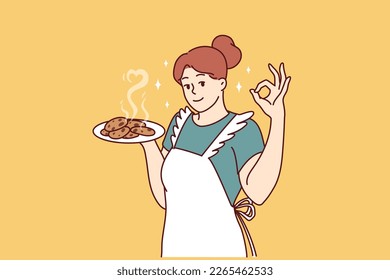 Un ama de casa sonriente en una plataforma de cocina preparando galletas caseras para invitar a la familia a desayunar. Una ama de casa positiva aprende a cocinar postres y pasteles, y quiere sorprender a su marido y a sus hijos 