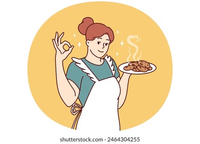 Smiling housewife in kitchen apron preparing homemade cookies to invite family for breakfast. Positive housewife learns how to cook desserts and pastries, wanting to surprise husband and children