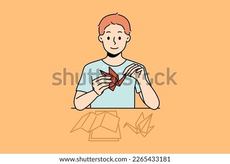 Smiling little boy sit at desk make origami. Happy kid enjoy hobby activity making birds from paper. Vector illustration. 