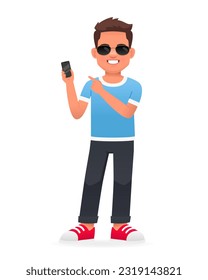 A smiling little boy stands in sunglasses and points to the phone in his hand. A beautiful cute white schoolboy kid in a blue T-shirt. Vector cartoon illustration on a white background.