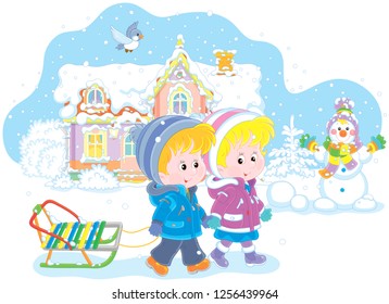 Smiling little girl and a boy walking with a small sled against a snow-covered house and a funny snowman, vector illustration in a cartoon style