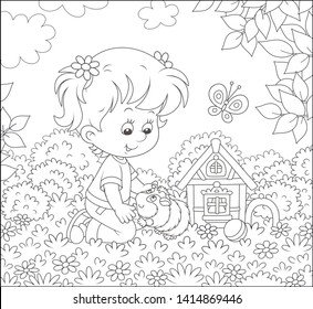 Smiling little girl playing with her small pet cavy among flowers on grass of a lawn on a sunny summer day, black and white vector illustration in a cartoon style for a coloring book