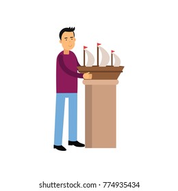 Smiling man character making model of sail boat. Male creative hobby. Vector flat cartoon illustration isolated on white.