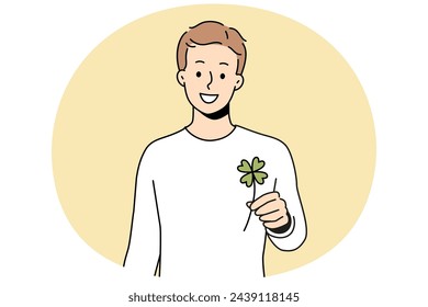 Smiling man holding clover with four leaves feeling lucky. Happy guy with trefoil in hands excited with good luck or fate. Superstition. Vector illustration.