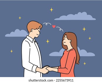 Un hombre y una mujer sonrientes parados bajo un cielo estrellado tomados de la mano. Una pareja feliz enamorada disfruta de una cita al aire libre por la noche. Ilustración vectorial. 