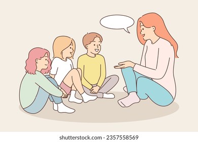 Smiling nanny sits on floor near children and tells interesting stories or riddles to wards. Young friendly teacher discusses plans for summer holidays with children and gives advice on right behavior