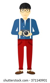 Smiling photographer holding camera.