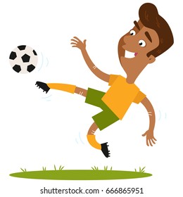 Smiling south-american cartoon footballer wearing yellow shirt and green shorts kicking the ball in mid-air isolated on white background.