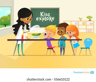 Smiling teacher and children looking through magnifying glass at green sprout during biology lesson in classroom. Preschool environmental education concept. Cartoon vector illustration for poster.