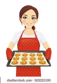 Smiling woman holding baking tray with homemade cookies wearing apron isolated