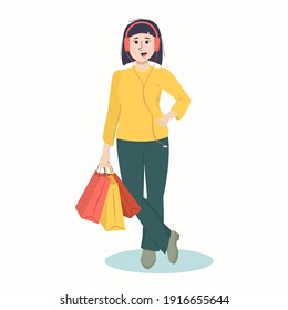 smiling young Asian woman wearing headphones with bags in her hands. The concept of sales and purchases. Isolated on a white background