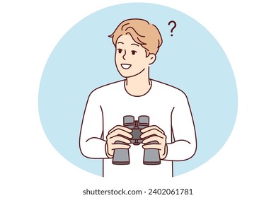 Smiling young man feeling confused holding binoculars in hands. Happy male frustrated looking in binocular finding solution. Exploration and discovery.