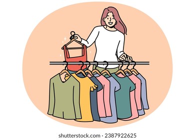 Smiling young woman buying clothes in fashion boutique. Happy female buyer or client choose apparel in shop. Style and consumerism. Vector illustration.