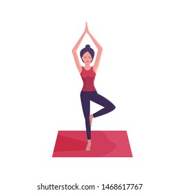 Smiling young woman practicing yoga, doing yoga exercise on pink mat, standing in tree pose, yoga pose, Vrksasana
