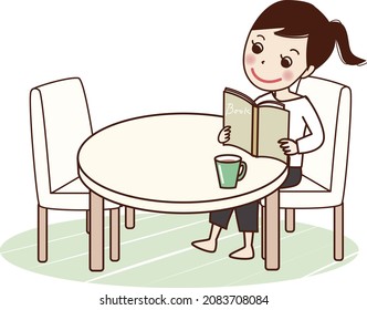 A smiling young woman reading a book at the table.