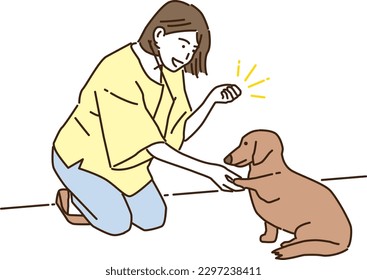 Smiling young woman training her dog
