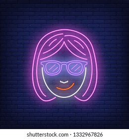 Smiling young woman wearing sunglasses neon sign. Avatar and fashion design. Night bright neon sign, colorful billboard, light banner. Vector illustration in neon style.