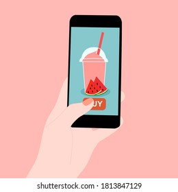 The smoothie juice in the glass cup with fruit (watermelon)​ beside. They are in online purchase with mobile app. A cold soft drink for summer.