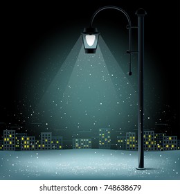 Snow in lamp lights. Christmas snowflakes falls on night city background. Large electric pillar