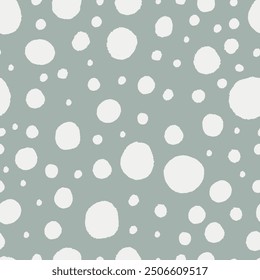 Snow seamless pattern. Hand drawn dots. White spots on pastel green background. Big and small blobs. 