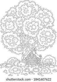 Snow-covered small wooden house from a fairytale with rustic decorations, a porch and an old fence under a big snowy tree on a pretty forest glade, black and white outline vector cartoon illustration