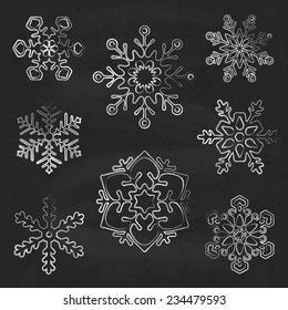 Siluetas de copo de nieve sobre fondo de tiza, vectorial de estilo dibujado a mano